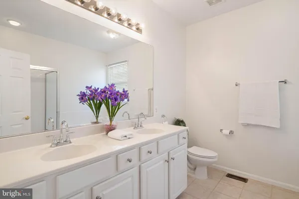 a bathroom with a granite countertop sink mirror and toilet