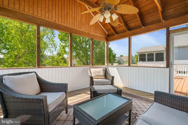 a view of a patio with couches chairs and wooden floor