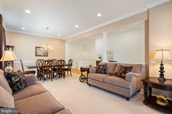 a living room with furniture and a dining table with kitchen view