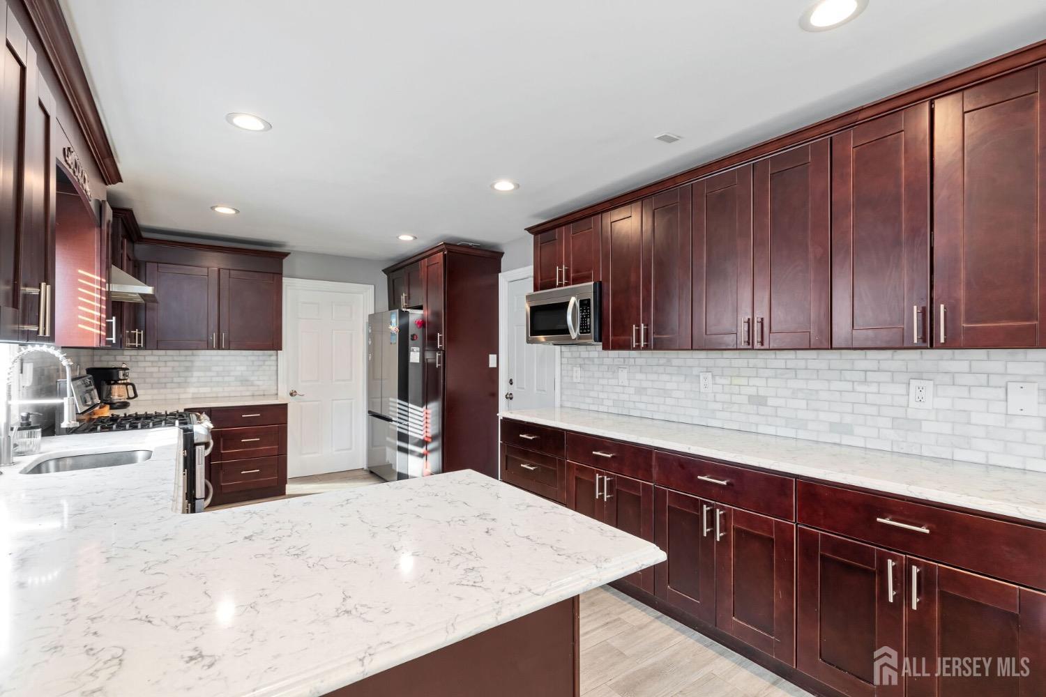 4 Indiana Road Somerset, NJ 08873 - Photo 12 of 31 a kitchen with stainless steel appliances granite countertop wooden cabinets a sink and dishwasher