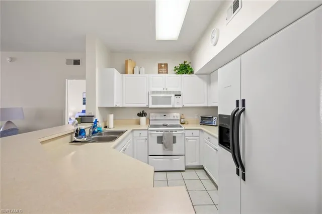 a kitchen with stainless steel appliances granite countertop a sink refrigerator and cabinets