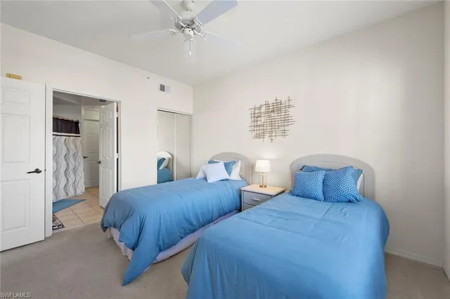 a bedroom with two beds and painting on the wall