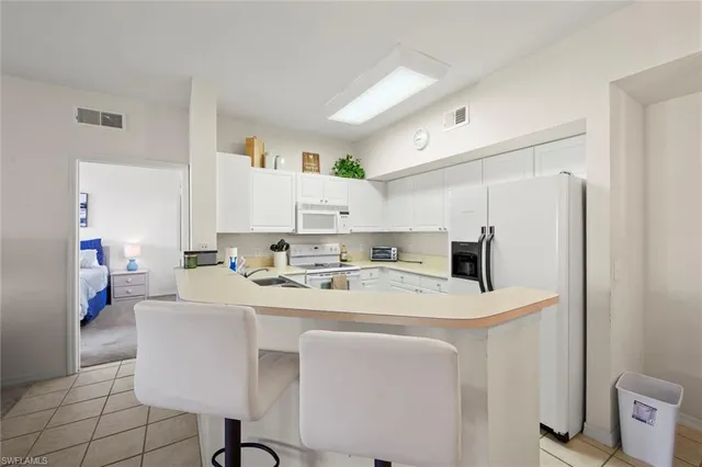a kitchen with a sink a stove a refrigerator and white cabinets