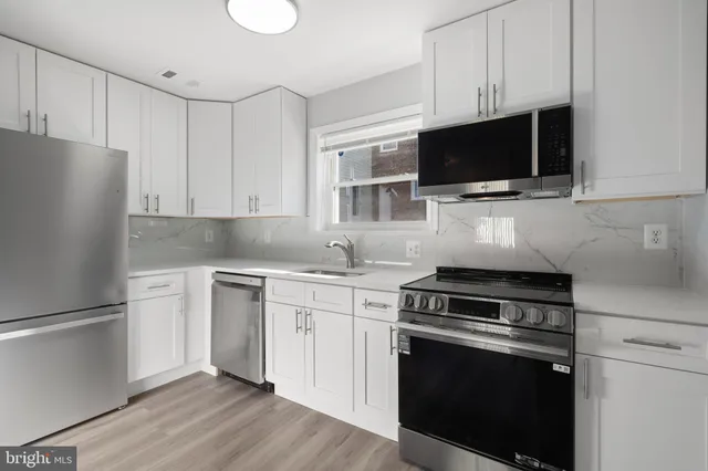 a kitchen with stainless steel appliances a stove microwave and sink