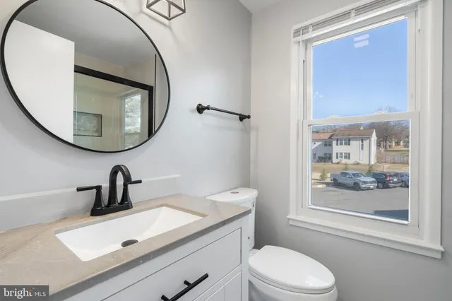 a bathroom with a sink a toilet and a mirror