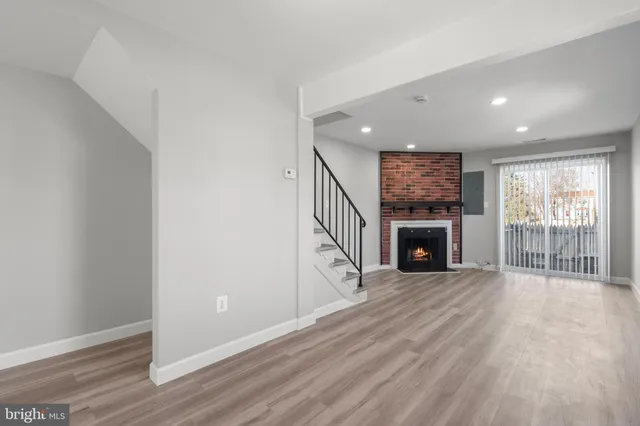 a view of empty room with wooden floor and fireplace