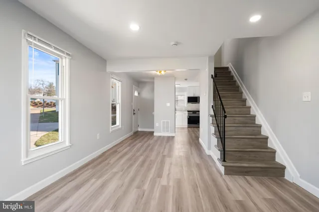a view of a hallway with wooden floor and entryway