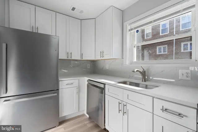 a kitchen with cabinets appliances and a sink
