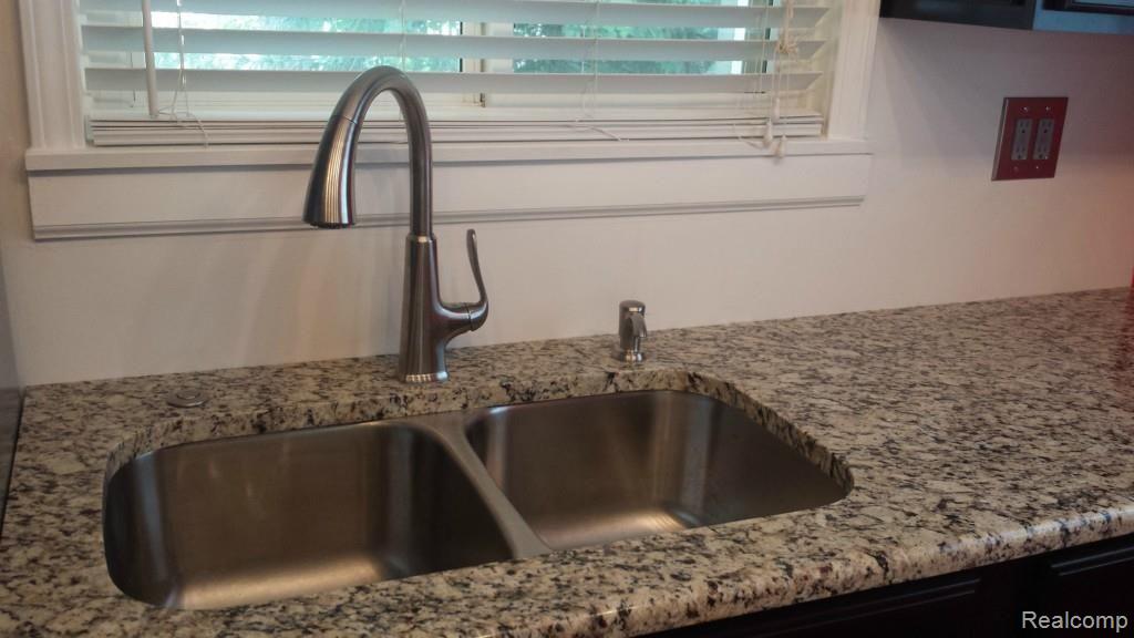 5369 Ridgemont Street Howell, MI 48843 - Photo 14 of 25 Goose-neck stainless steel faucet with tasteful granite-disposal button built into the counter top.