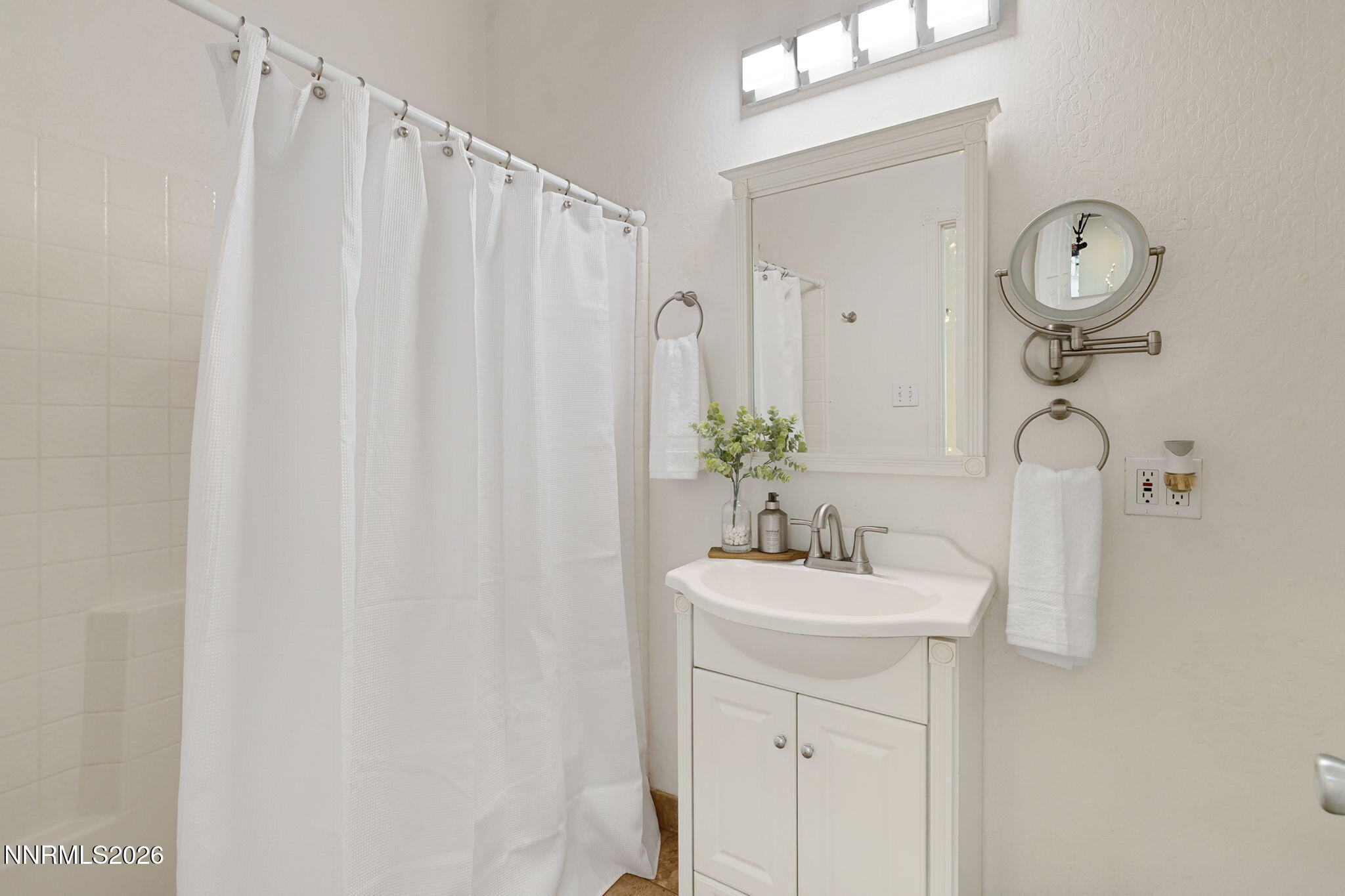 5520 High Rock Way Sparks, NV 89431 - Photo 39 of 75 a bathroom with a sink a mirror and a shower curtain