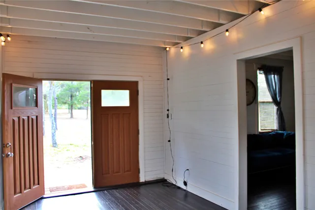 a view of a hallway with wooden floor and stairs