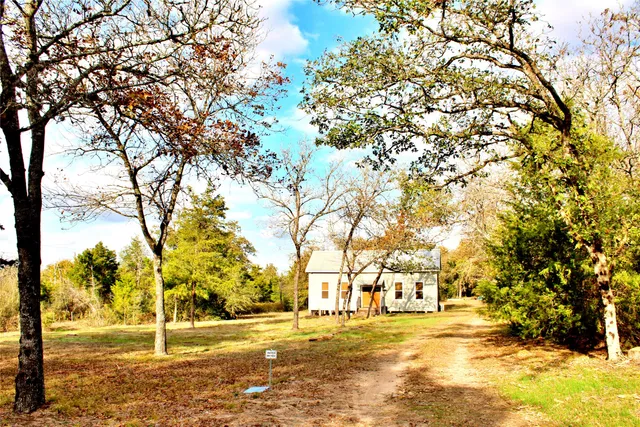 a backyard of a house with large trees