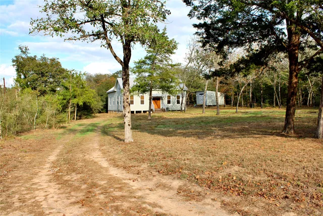 a view of a small house with backyard