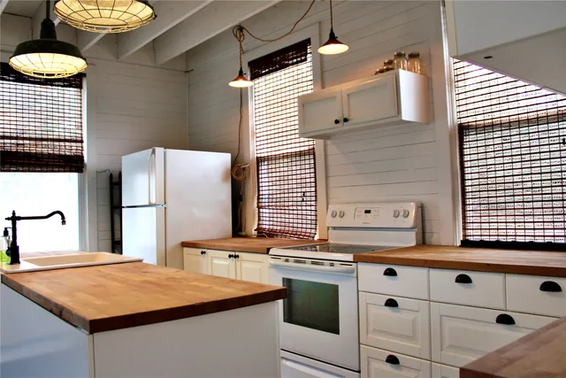 a kitchen with stainless steel appliances granite countertop a stove a sink and a refrigerator