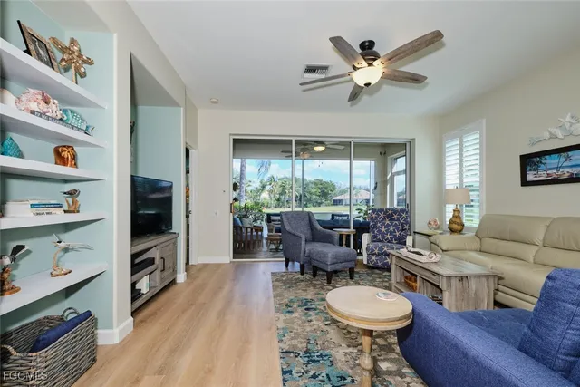 a living room with furniture a flat screen tv and a window