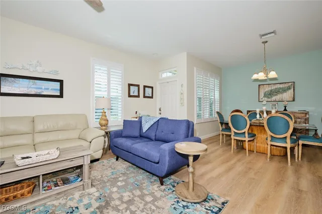 a living room with furniture a wooden floor and a chandelier