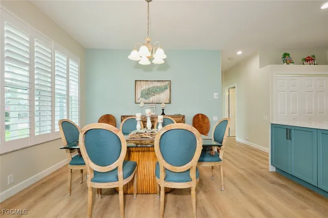 a dining room filled chandelier and wooden floor