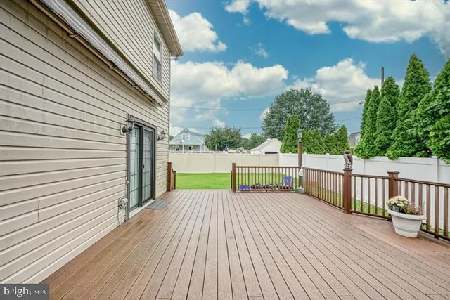 a view of a deck with wooden floor and fence with a bench