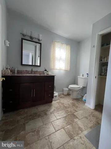 a bathroom with a toilet a sink and mirror
