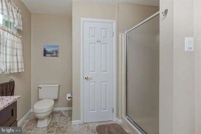 a bathroom with a toilet and a shower