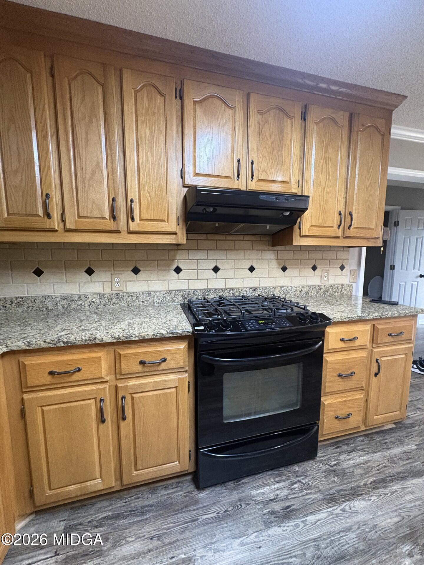 5081 Marshall Mill Road Lizella, GA 31052 - Photo 13 of 40 a kitchen with granite countertop a stove a sink and a microwave