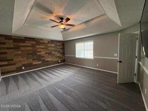 an empty room with a window and a fan