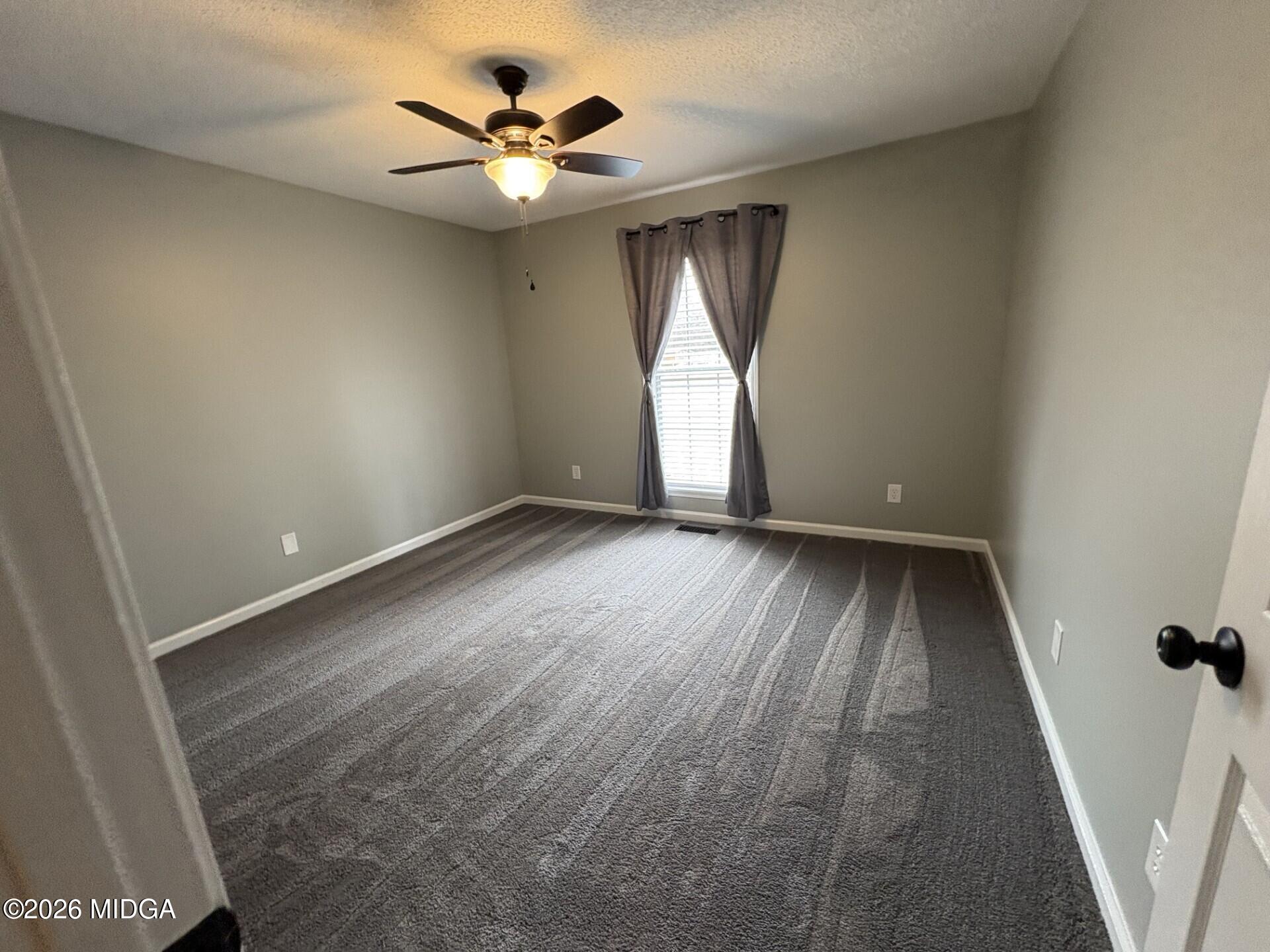5081 Marshall Mill Road Lizella, GA 31052 - Photo 22 of 40 an empty room with a window and a fan