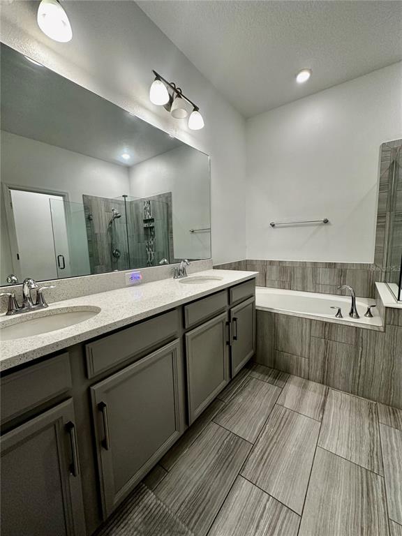12351 Northover Loop Orlando, FL 32824 - Photo 29 of 58 a spacious bathroom with a double vanity sink a mirror and a bathtub