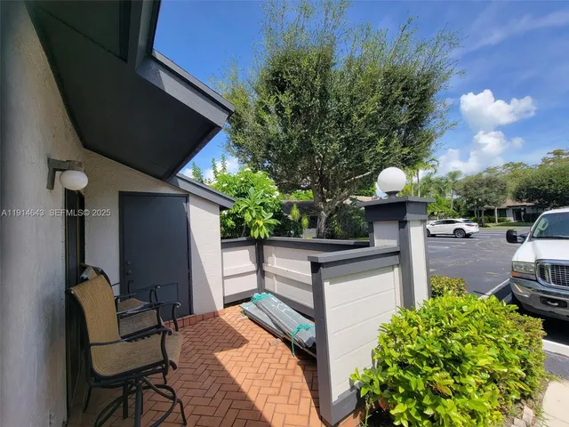 a backyard of a house with table and chairs potted plants