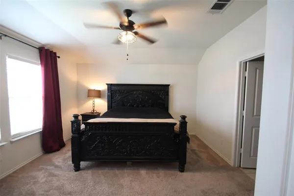 a bedroom with a bed and a ceiling fan
