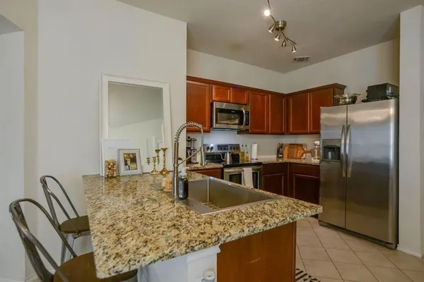 a kitchen with kitchen island granite countertop a stove top oven a sink a dining table and chairs