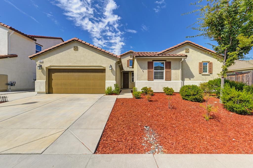 a front view of a house with yard garage and outdoor seating