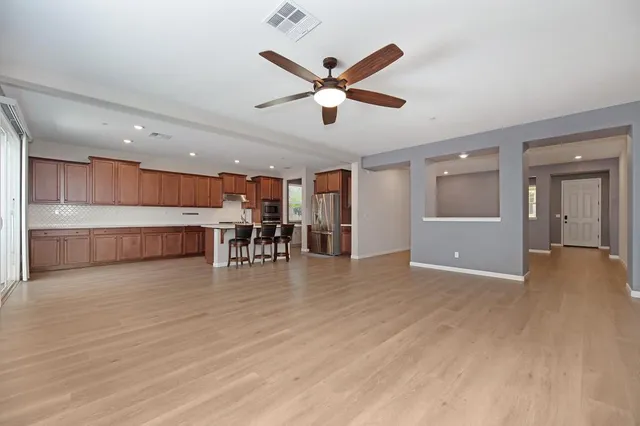a view of a livingroom with a ceiling fan and wooden floor