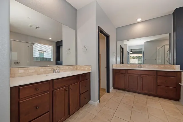 a spacious bathroom with a granite countertop sink and a mirror