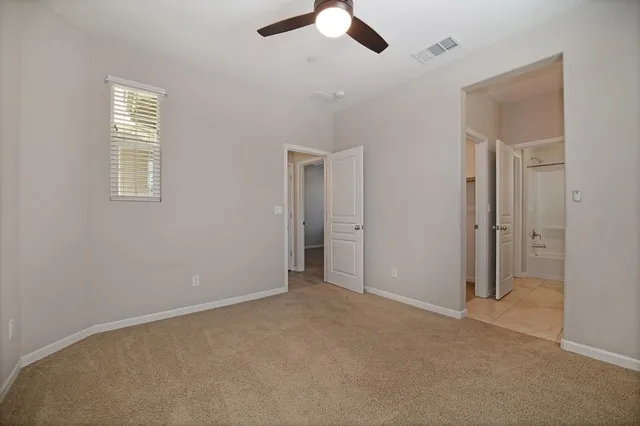 an empty room with chandelier fan