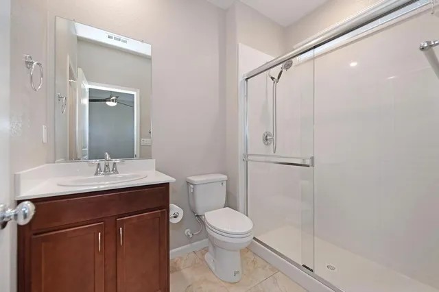 an empty room with a window and a ceiling fan