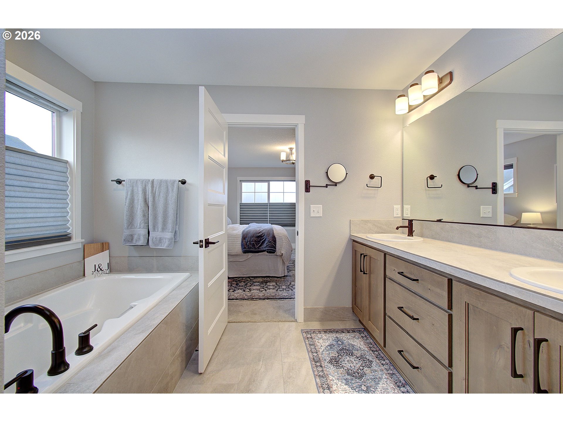 2831 Northeast 9th Avenue Battle Ground, WA 98604 - Photo 32 of 43 a spacious bathroom with a double vanity sink a mirror a bathtub and shower