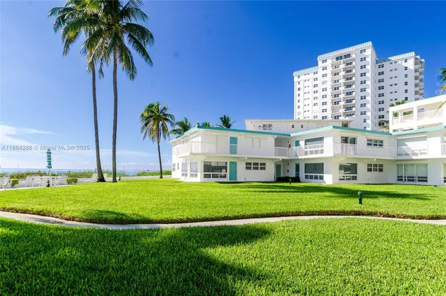a front view of building with yard and trees