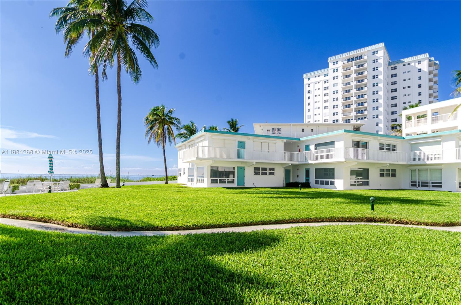 a front view of building with yard and trees