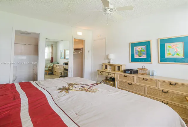 a bed room with a bed and a view of kitchen