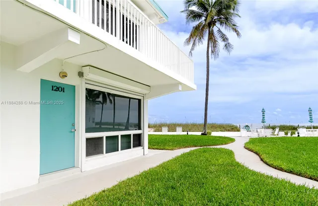 a view of a house with a yard and potted plants