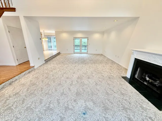 a view of a room with wooden floor staircase and a ceiling fan