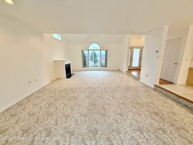 an empty room with a window and a ceiling fan