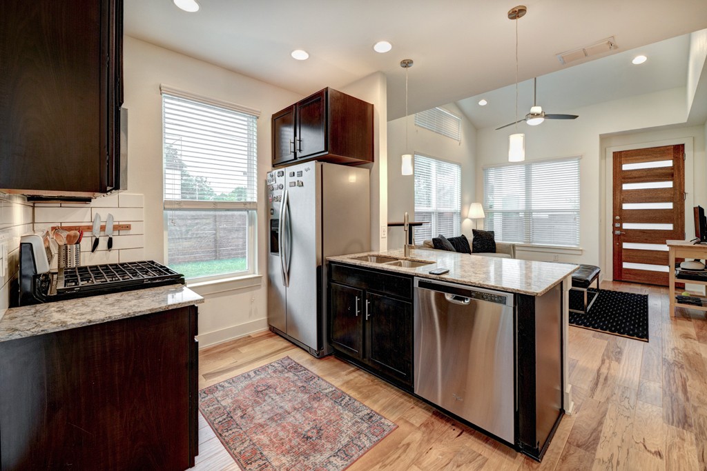 1300 Walnut Avenue, Unit B Austin, TX 78702 - Photo 5 of 15 a kitchen with stainless steel appliances granite countertop a sink stove and refrigerator