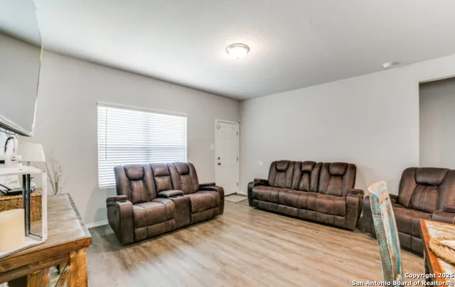 a living room with furniture and wooden floor