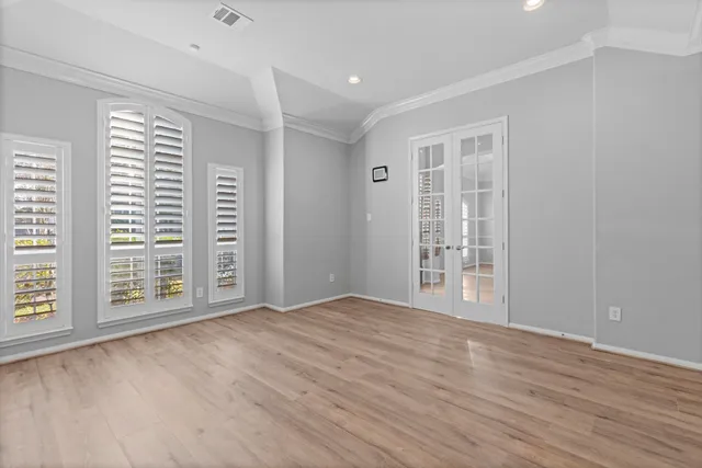 a view of an empty room with a window and wooden floor