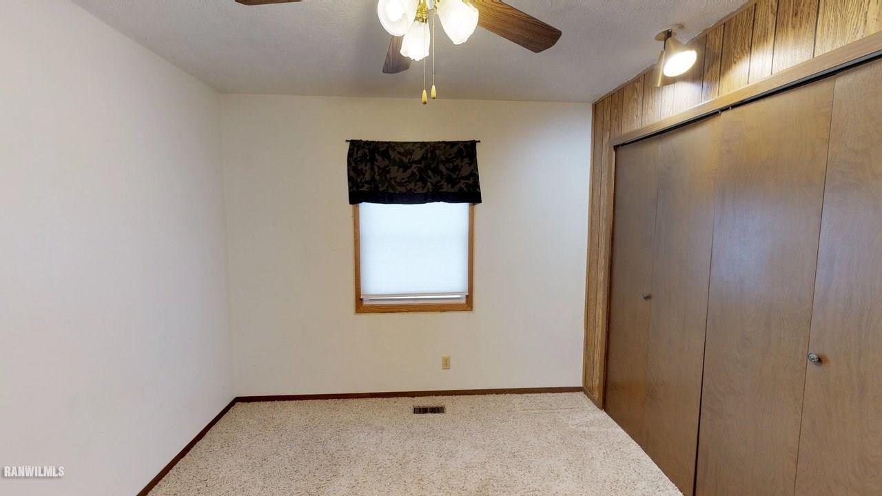 11280 Benson Road Lanark, IL 61046 - Photo 15 of 20 en empty room with a chandelier fan and a window