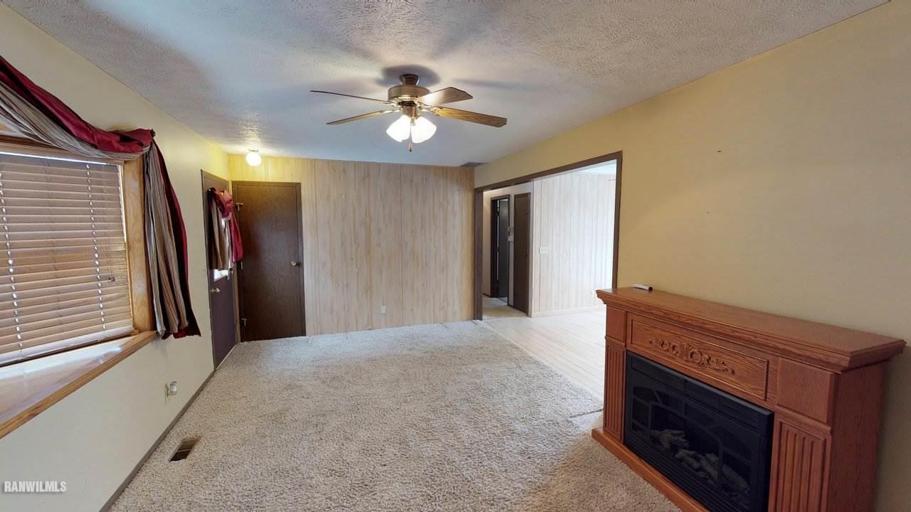 11280 Benson Road Lanark, IL 61046 - Photo 6 of 20 a view of a livingroom with a chandelier fan and a fireplace
