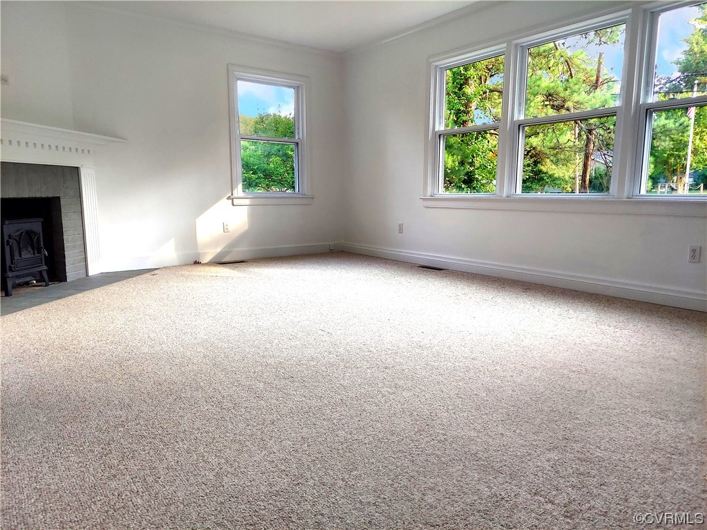 14413 Rivermont Road Chester, VA 23836 - Photo 4 of 21 an empty room with a fireplace and windows