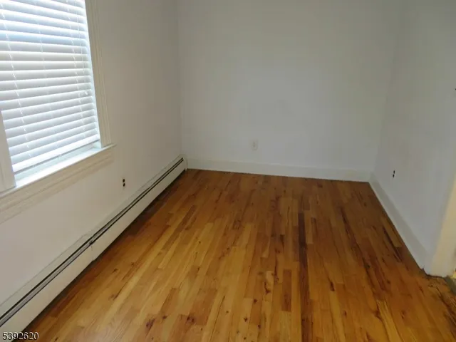a view of a room with wooden floor and small window